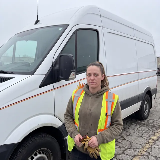 Truck driver standing with a Shipluxe LLC truck