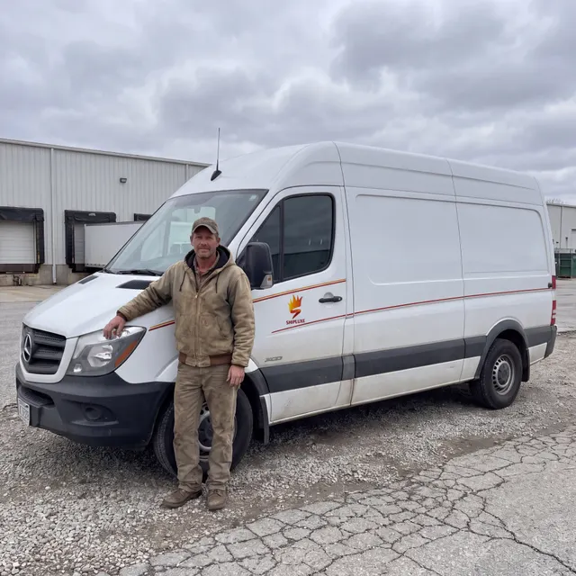 Truck driver standing with a Shipluxe LLC truck